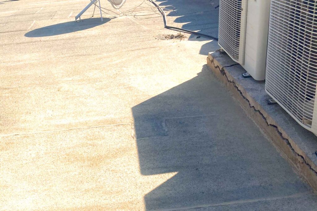 Air conditioning equipment foundation on mosque rooftop requiring waterproofing treatment and roof penetration sealing during restoration works.